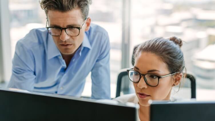 Zwei Personen diskutieren vor einem Monitor