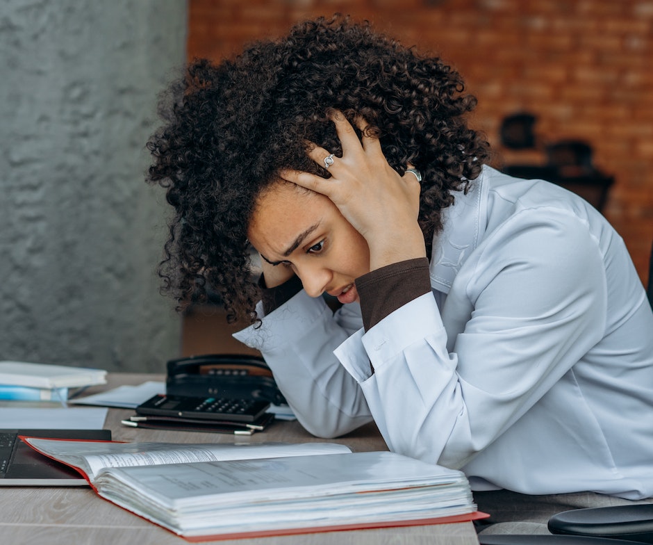 Femmes stressées en position assise qui lisent un livre en se tenant la tête 