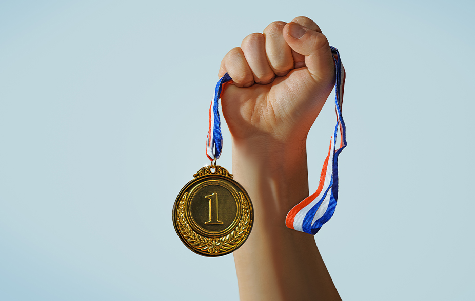 main brandissant une médaille d'or