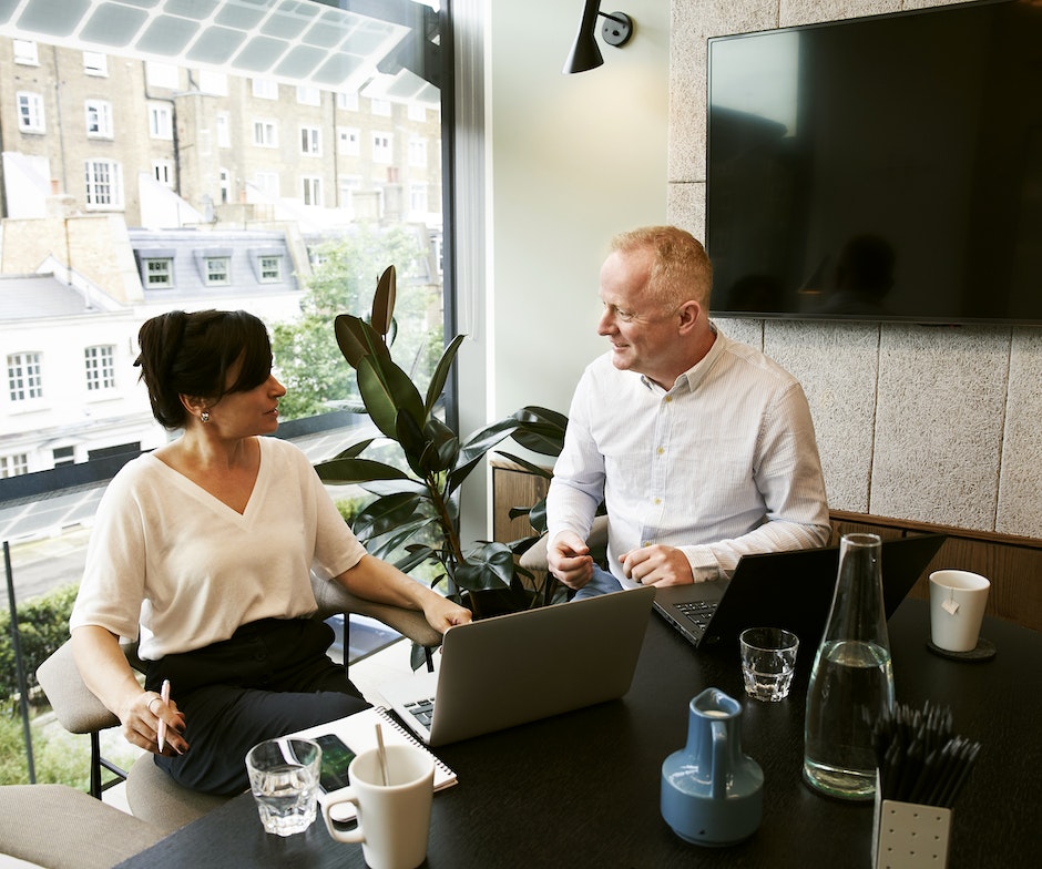 two people talking at a desk