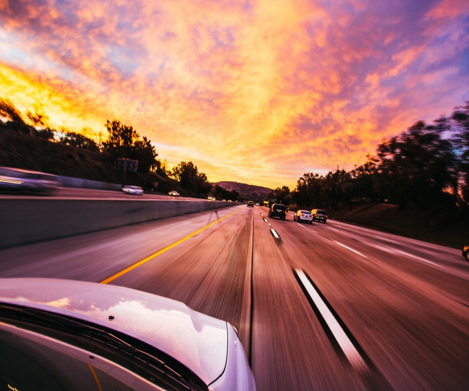 A car driving on the highway at sunset