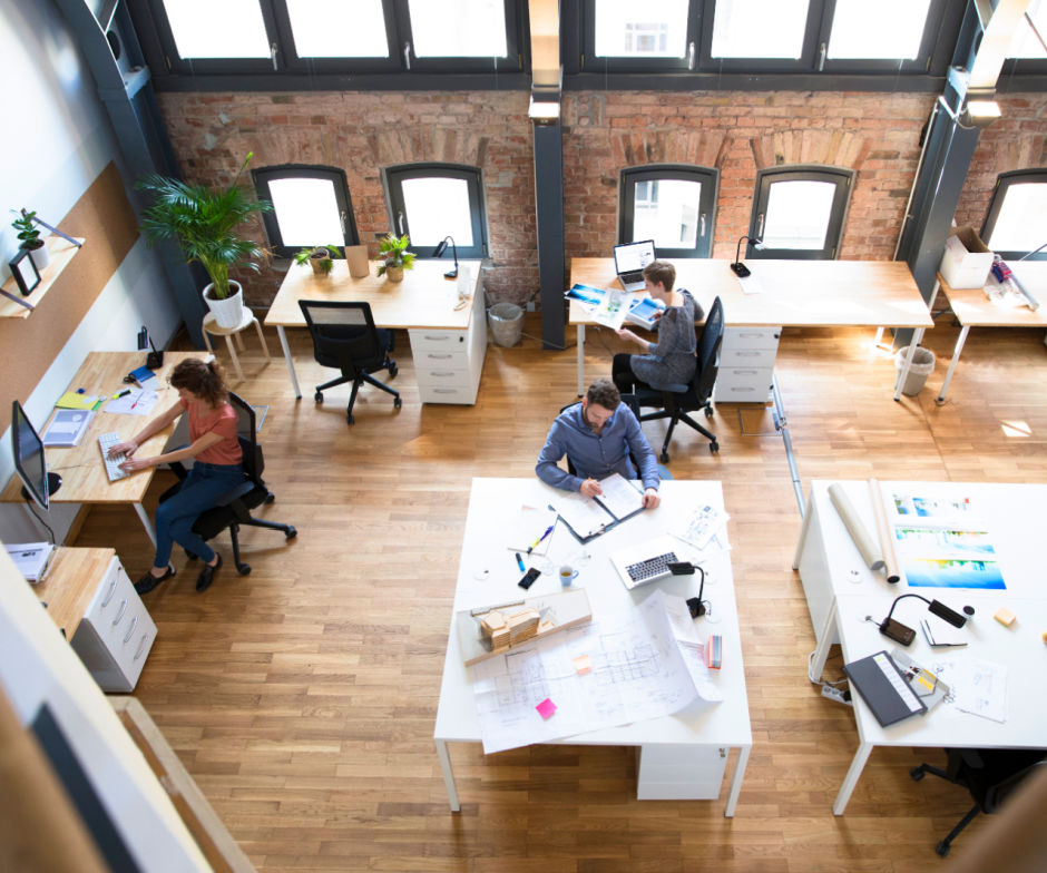 employees sitting inside room with desks and monitors