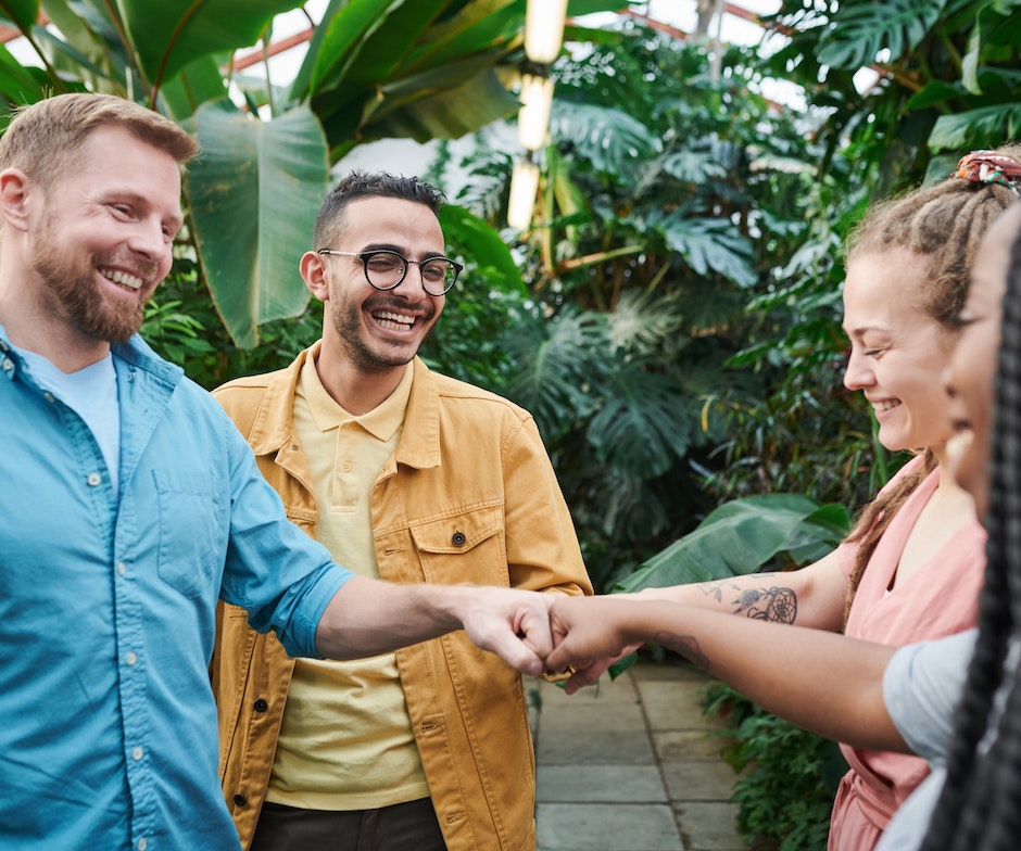 four people fist bumping