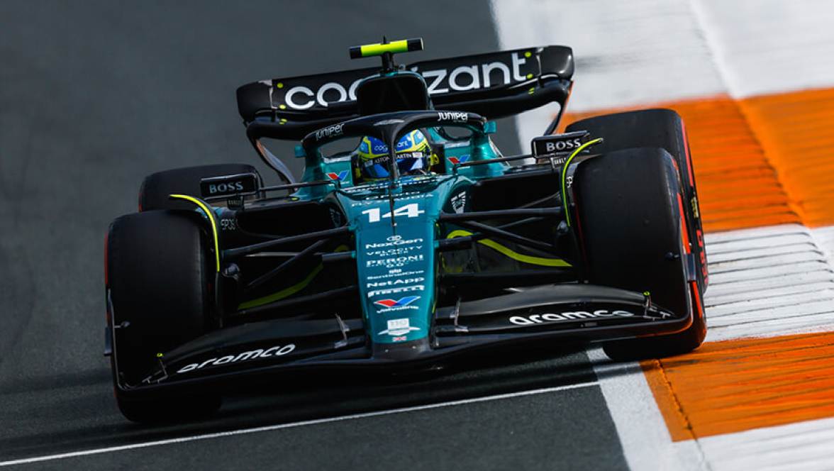 Vista dianteira do carro da F1 Aston Martin, inclinado na curva em uma pista