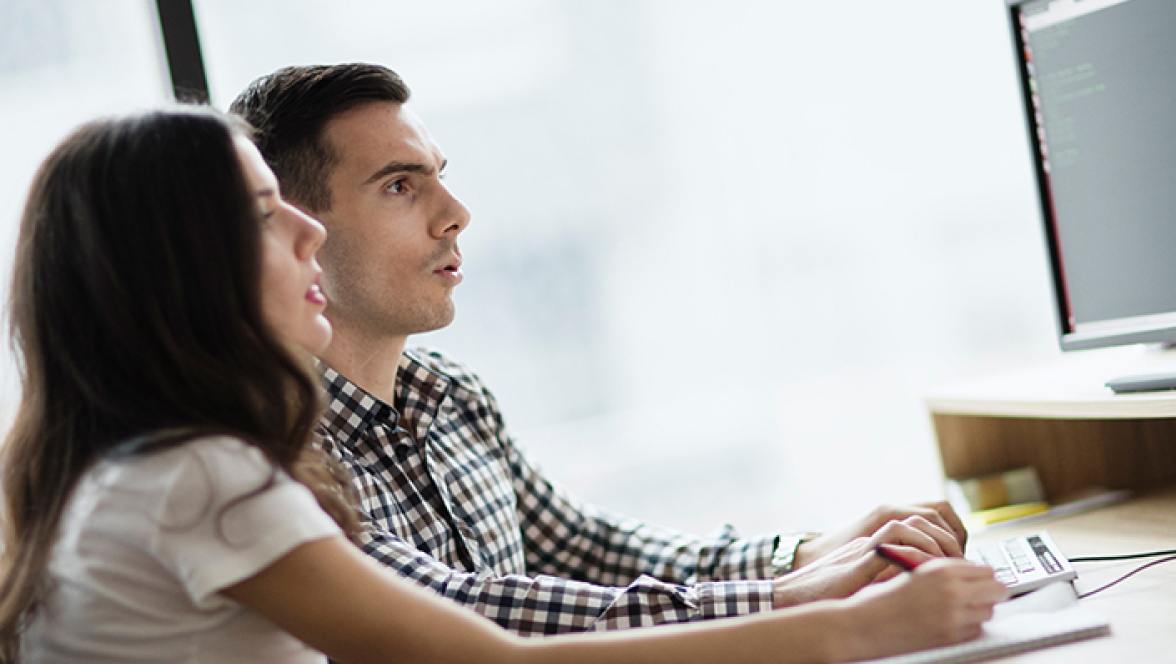 Duas pessoas olhando para o monitor